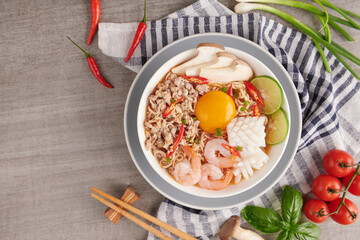 Tom Yum Soup, Thai Food, Instant noodles, Tom Yum Goong spicy shrimp soup with Thai spices placed on Dark background. Mixed tom yum, pork, squid, shrimp, egg, Thai-Asian food mixing concept.