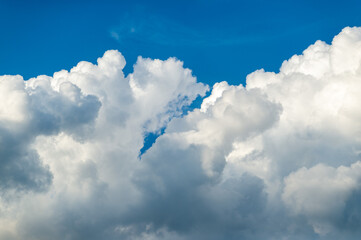 Cumulus clouds. Background with white clouds floating above the ground at flight altitude. Picture for weather forecast.