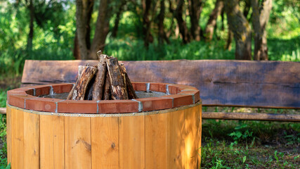 Fototapeta premium Place for campfire with wooden bench at glamping