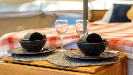 Tent interior with bed and dishes set at glamping