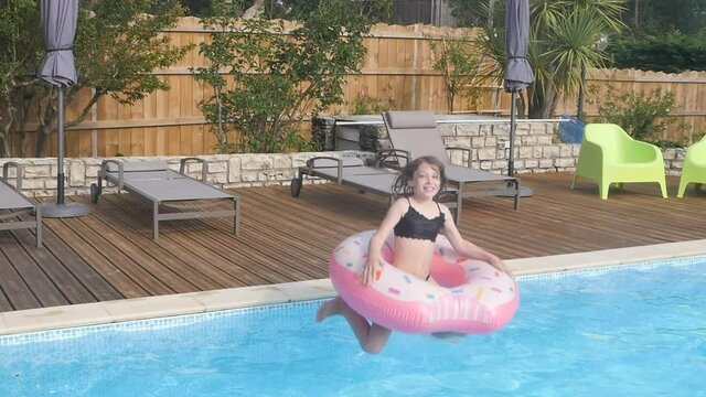 pretty young girl diving and jumping in a swimming pool