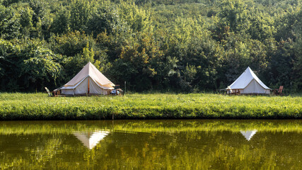 Glamping, few tents, lake on the foreground