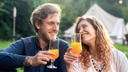 A happy couple resting in the nature at glamping