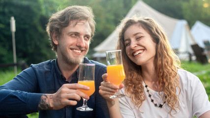 A happy couple resting in the nature at glamping
