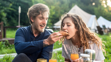 A happy couple resting in the nature at glamping