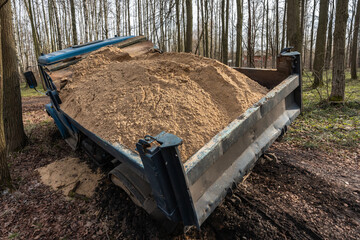 Dump truck car stuck in mud on the road. Blurry mud bad road in the park. Тruck dump car with sand...