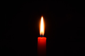 Single red candle in the dark.