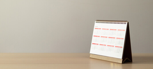 Calendar page close up on wood table with white wall background business planning appointment...