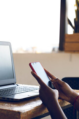 Close-up side view of female fingers typing on laptop keyboard in the meeting room