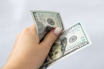 100 dollars in hand close-up on a white isolated background. A hundred-dollar bill