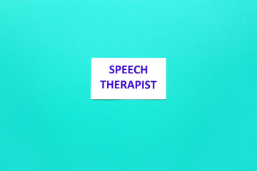 Paper sheet with text SPEECH THERAPIST on color background