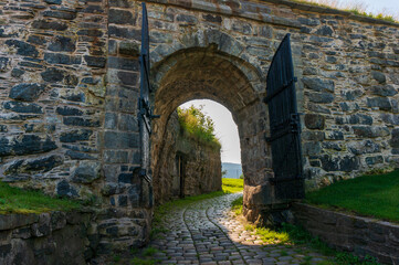 Fototapeta na wymiar Fredriksberg Festning. Entrance gate to the medieval fortress. Cobblestone road. Bergen, Norway.