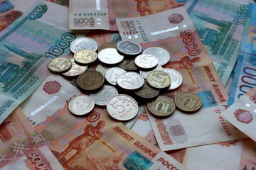 Paper ruble bills with a pile of small metal coins