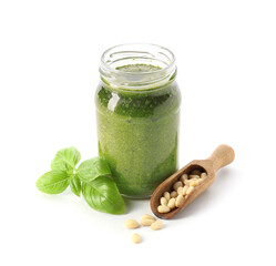 Jar with fresh pesto sauce and ingredients on white background