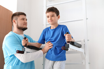 Fototapeta premium Physiotherapist working with boy in rehabilitation center