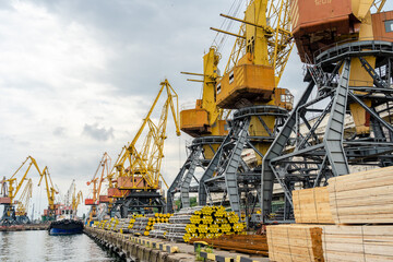 Metal pipes and stacks of timber ready for shipment in sea port in Ukraine