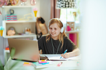 happy pupil in grey shirt homeschooling at home in sunny day