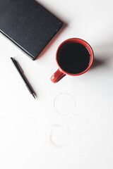 Blank organizer with pen and empty and full red coffee cups. Isolated on white background