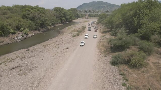Reveal and tilt footage over a dry river and a steel bridge, showing effects of climate change