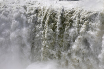 Natural background. Power in water. Closeup view of the famous Iguazu falls in Misiones, Argentina. The mist and falling white water beautiful texture, motion and pattern.