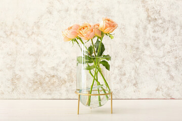 Vase with beautiful peony roses on light background