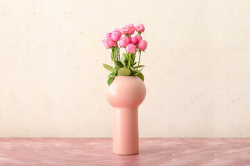 Vase with beautiful peony roses on color background