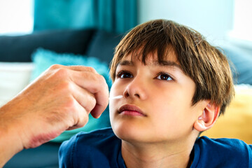 A parent do Covid-19 selftest at home for a son elementary age. A hand holding a cotton swab...