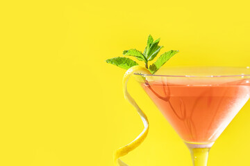 Glass of tasty cosmopolitan cocktail on color background, closeup