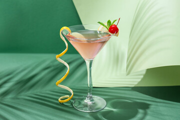 Glass of tasty cosmopolitan cocktail on color background