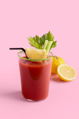 Glass of bloody mary cocktail and lemons on color background
