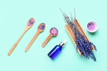 Composition with bottle of lavender essential oil, spoons with sea salt and flowers on color background