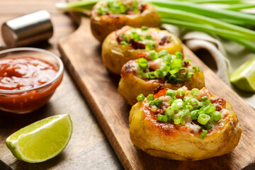 Tasty baked potato and sauce on table, closeup