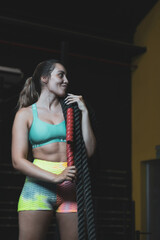 Obraz na płótnie Canvas a Colombian girl posing with ropes in a gym.