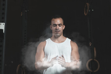 a Turkish man putting magnesium on his hands before training in a gym.