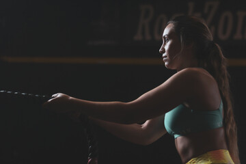 a Colombian girl pulling a rope inside a gym.