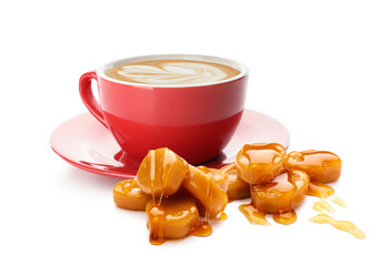 Cup of tasty cappuccino with caramel candies on white background