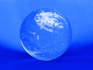 Transparent clear crystal ball on a blue background