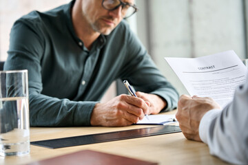 Businessman signing trust partnership contract at meeting with partner, manager or lawyer sitting...