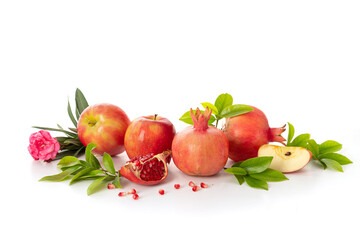 Pomegranates and red apples on white background, traditional food of Jewish New Year - Rosh Hashanah.