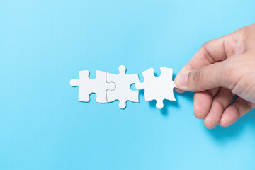Hand push a piece of jigsaw puzzle to complete the mission for business merging concept or coorperate acquisition