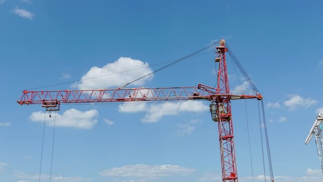 High industrial tower crane at construction site of new residential building. Time lapse