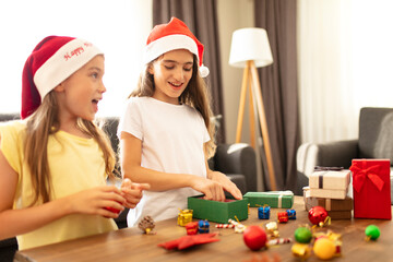 Naklejka premium Two sisters preparing gift wrapping for Christmas. Christmas concept beautiful photo. 