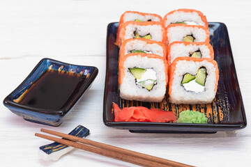 Sushi roll Philadelphia on the plate over white wooden table background.
