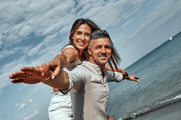 Cheerful young couple enjoying the summer time. - obrazy, fototapety, plakaty