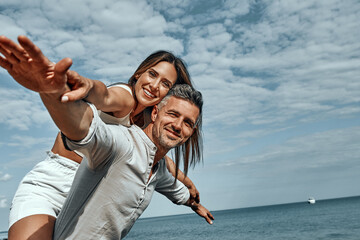 Happy young couple enjoying a solitary beach back riding.