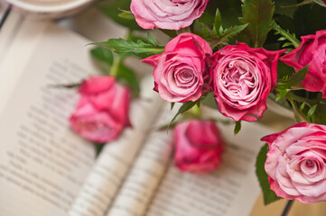 Beautiful pink roses with opened book in the background