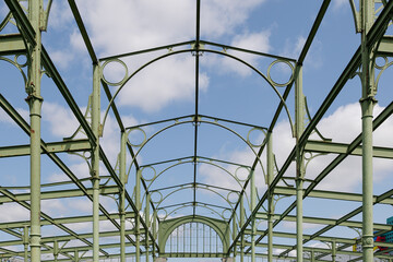 Fototapeta premium Detail of existing retro steel roof green structure of old industrial building against blue sky in Berlin, Germany.
