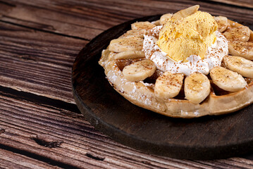 Waffle with dulce de leche, banana, ice cream and cinnamon powder