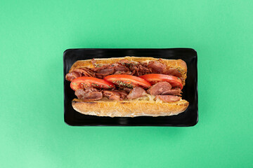 sandwich on ciabatta bread with pepperoni sausage, cheese, tomato and oregano