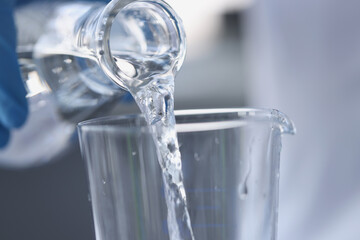 Water is poured from transparent bottle into glass